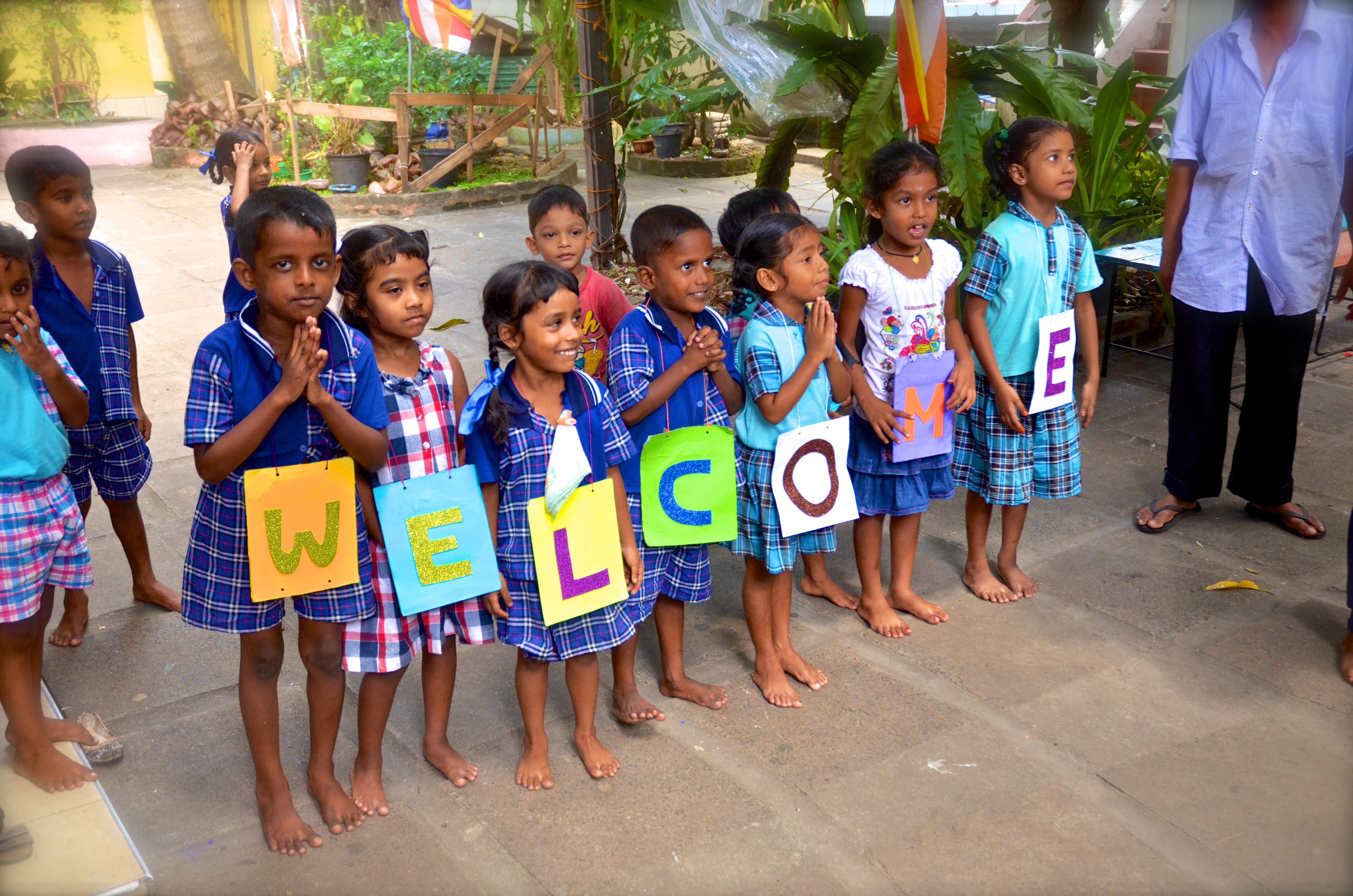 Volunteers doing childcare work in Sri Lanka as a group, are welcomed to their placement by the children. Projects Abroad volunteers doing community work in Sri Lanka as a group, are welcomed by young children.